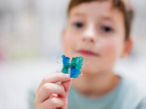 Child holding a retainer from our Krum orthodontist