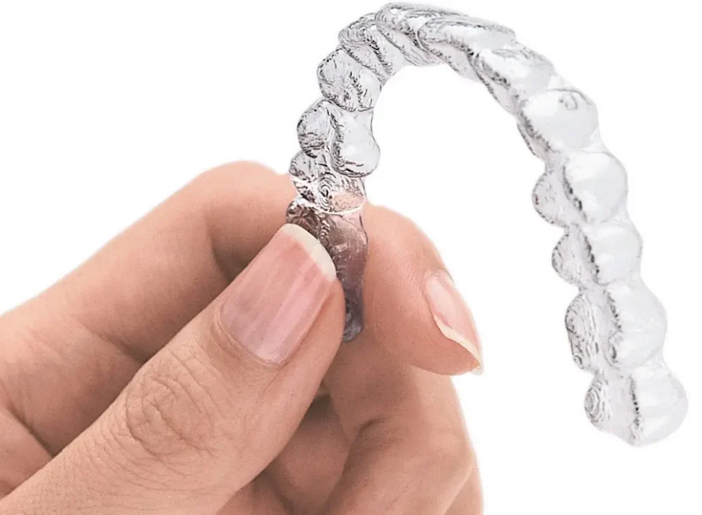 A Hand Holding An Invisalign Tray