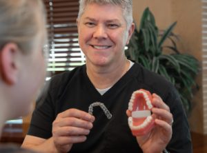 Dr. Cramer showing a patient Invisalign in Krum, TX